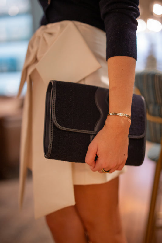 Model wearing an elegant holiday party skirt holding the Allie tweed evening clutch bag in her hand.
