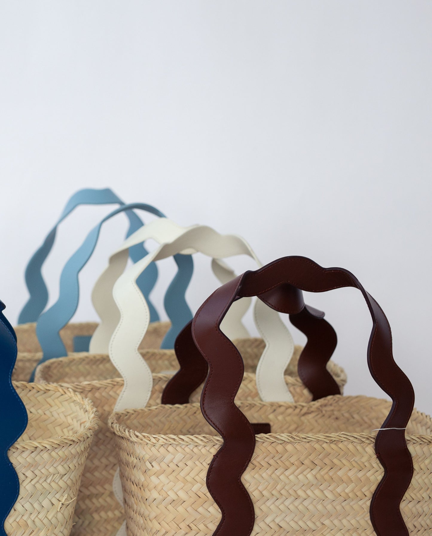 Wicker baskets in different coloways on a white background