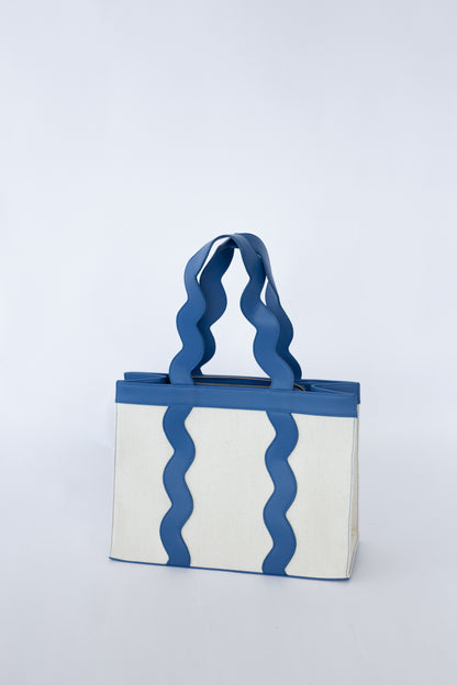 Tote bag with scalloped blue handles and pattern on a white background