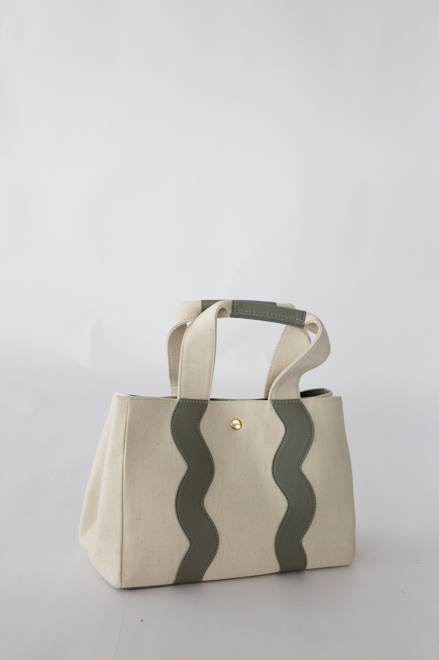 Handbag with scallop pattern on a white background.