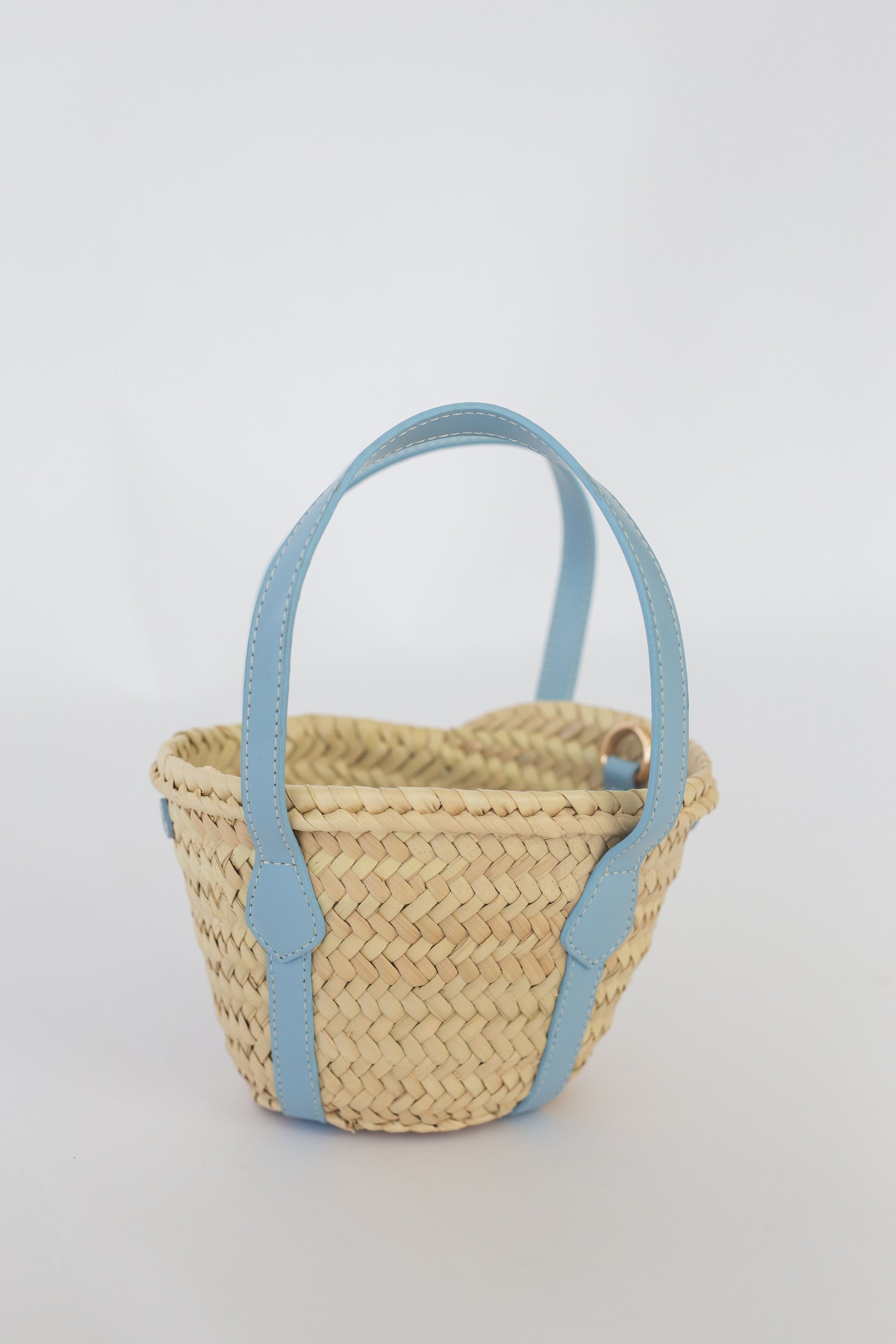 Woven basket with light blue handles on a white background