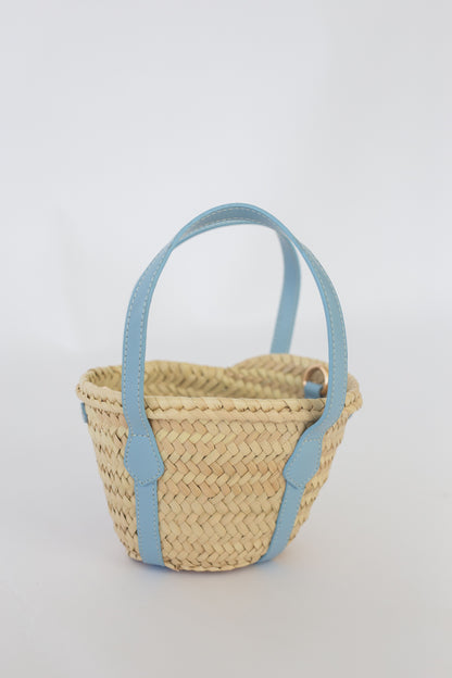 Woven basket with light blue handles on a white background