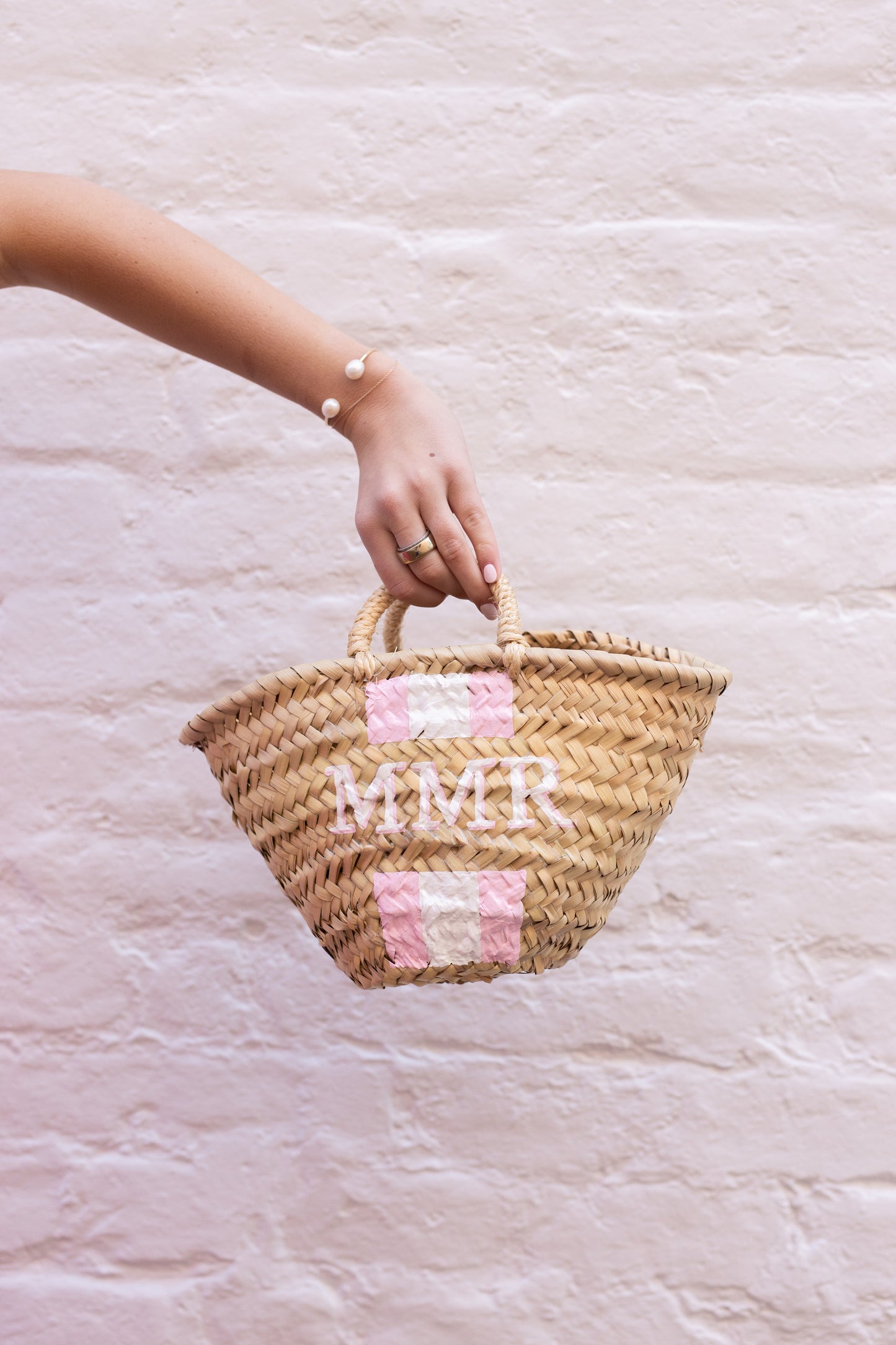 The Quinn mini tote displayed with an alternative hand-painted color combination featuring soft pastel pink and white vertical stripes.