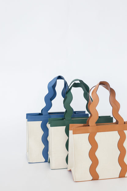 Three colorful tote bags with wavy handles on a white background