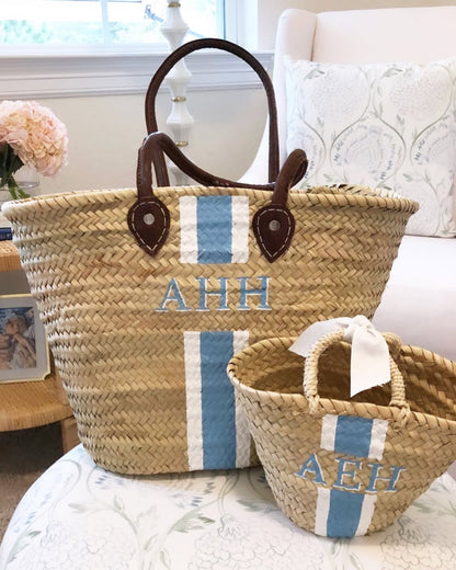 Custom hand-painted Mommy and Me basket bags sitting in a daughter's nursery.