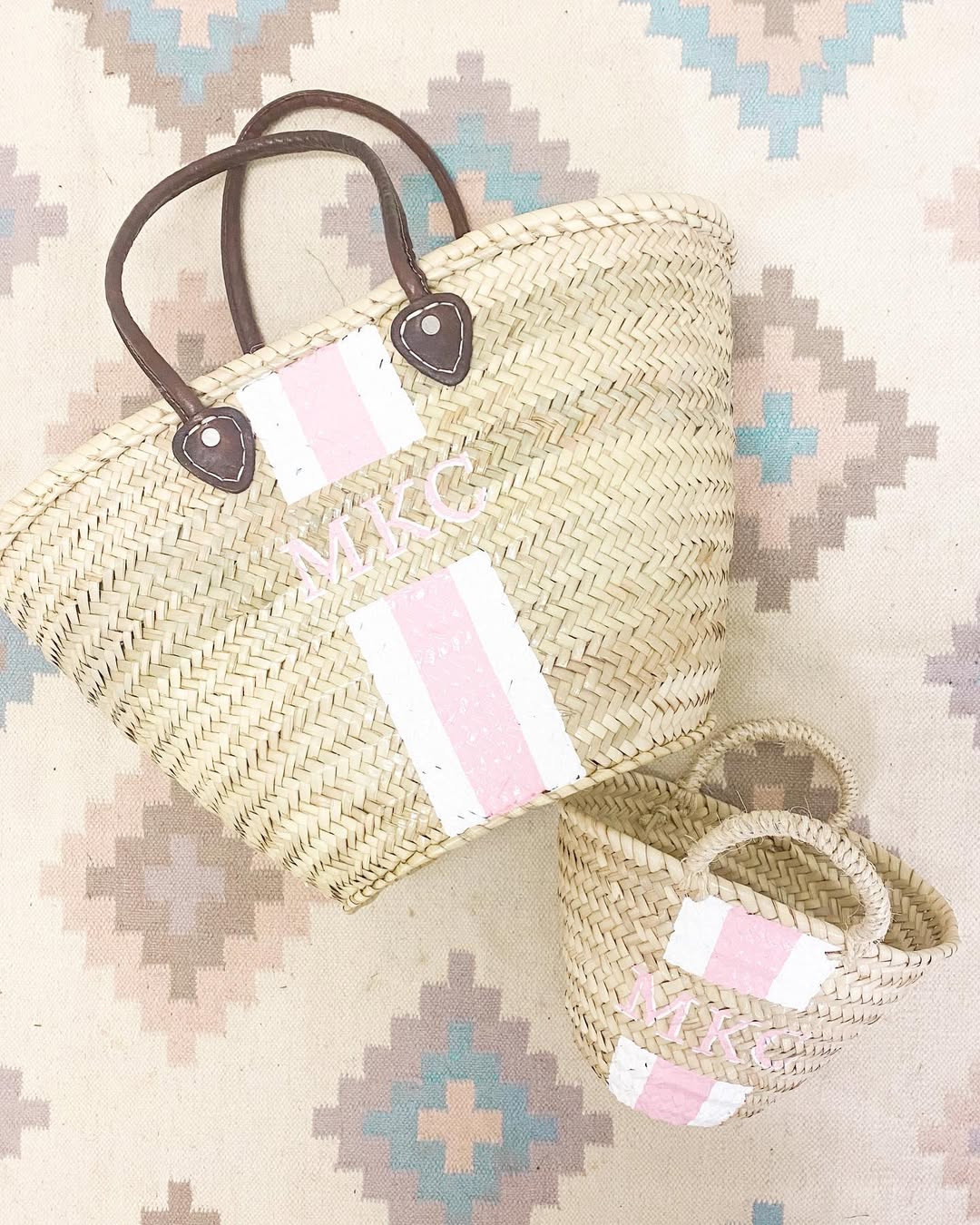 Close-up view of the adorable small baby Quinn hand-woven straw basket purse with genuine leather handles and the large Brecky Tote for mom. 