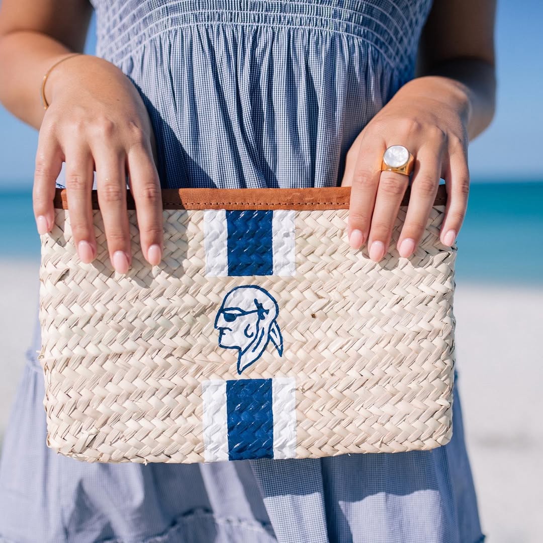Close up of hand-painted Gasparilla Inn logo on the woven Mimi Clutch bag