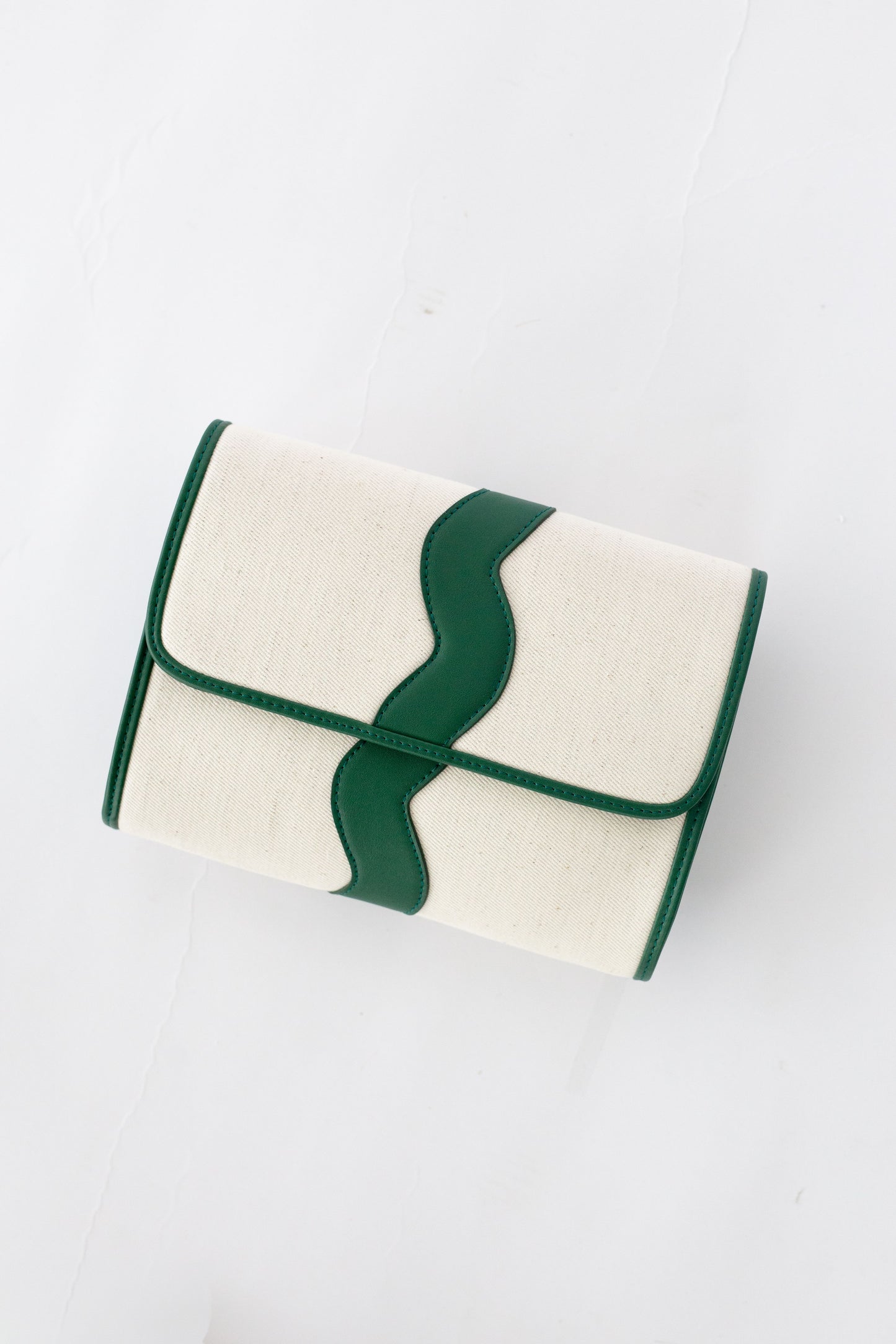 White clutch bag with green leather scallop on a white background