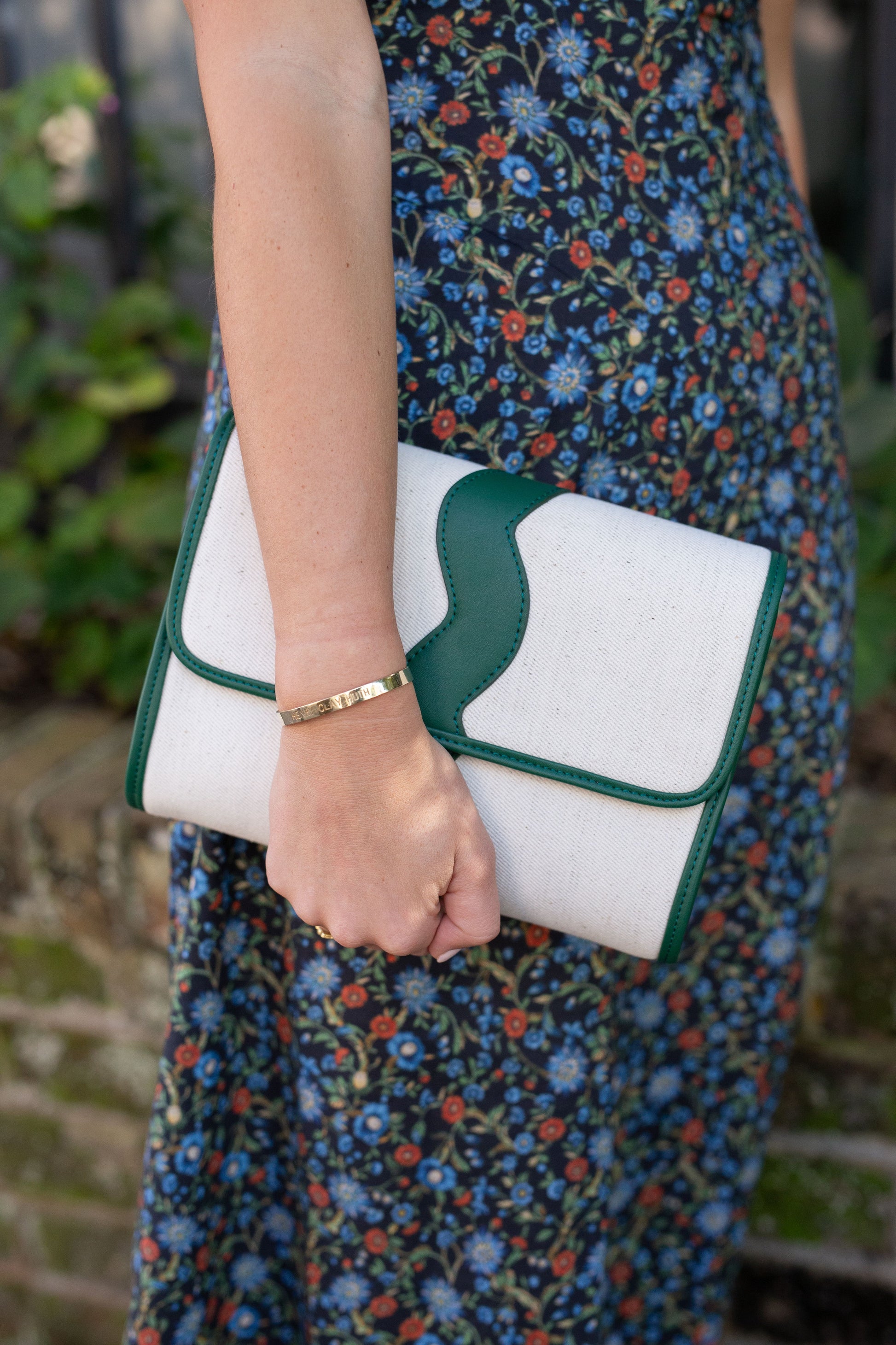 Full front view of the structured Allie cream canvas clutch showcasing the unique wavy top border details.