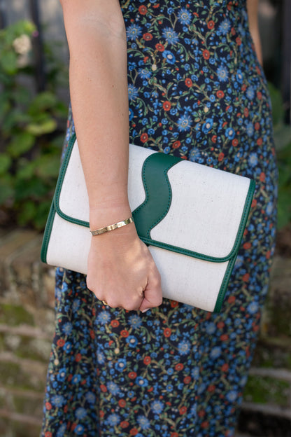 Full front view of the structured Allie cream canvas clutch showcasing the unique wavy top border details.