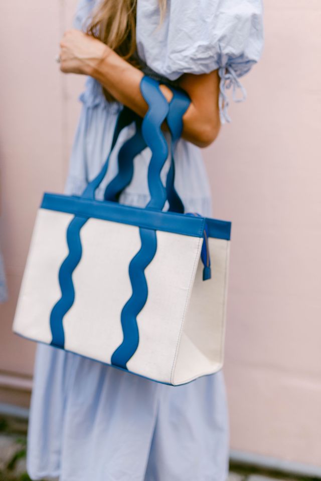 The Grier scalloped canvas tote displayed in a blue leather trim color option.