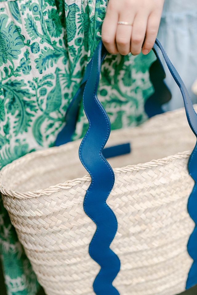 Close-up shot highlighting the premium, high-density artisan weave of the natural straw and the quality stitching on the navy blue leather handles.