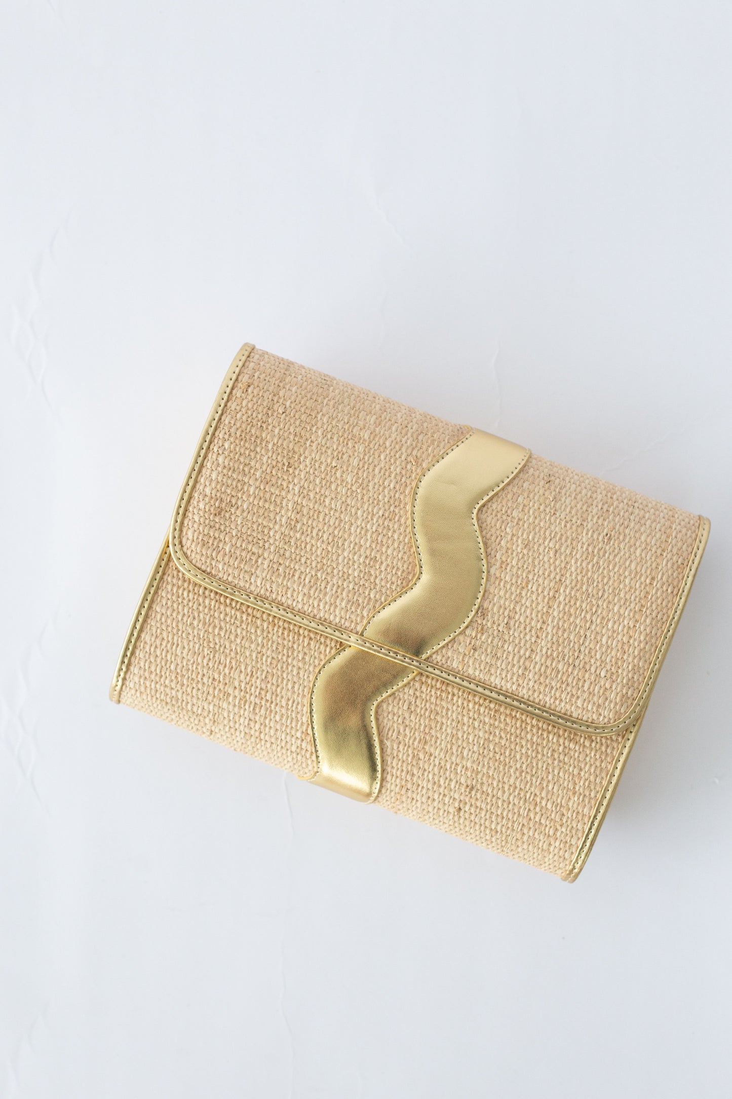 Gold rattan clutch on a white background