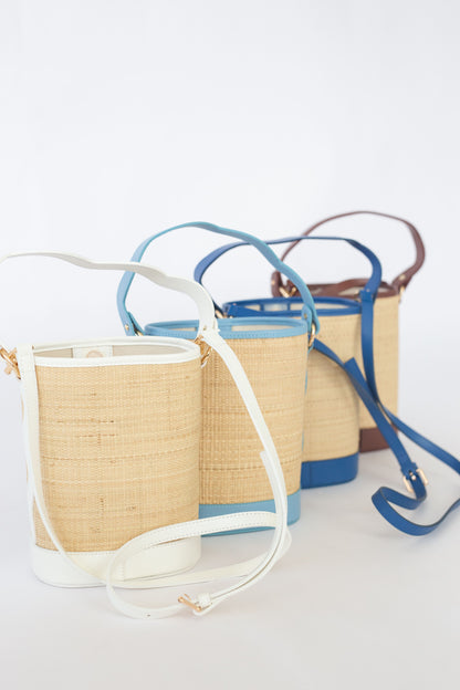 Three woven handbags with a variety of color straps on a white background